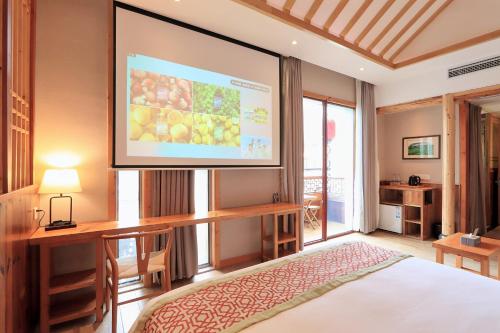 a large screen in a room with a bed at Mild Spring Boutique Hotel in Huangshan