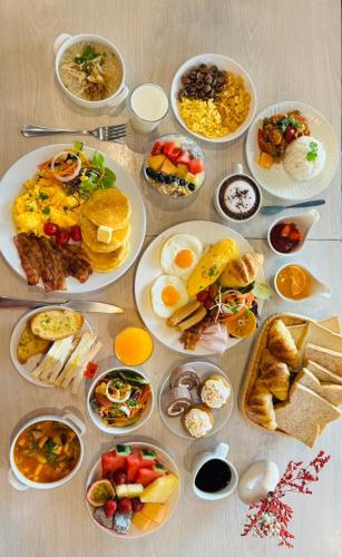 a table with plates of breakfast food on it at Le Naview @Prasingh in Chiang Mai