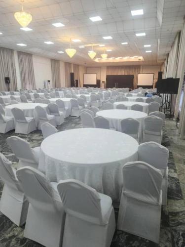 a large room with white tables and white chairs at WACOP HOTEL & CONFERENCE CENTRE, Gaduwa, Abuja in Abuja
