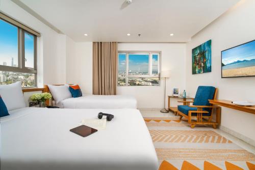 岘港Ocean Bliss Hotel - Free Sauna的有两张床和一张书桌的酒店房间