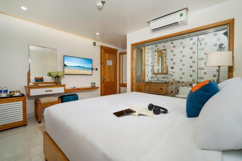 a bedroom with a large white bed with shoes on it at Ocean Bliss Hotel - Free Sauna in Da Nang