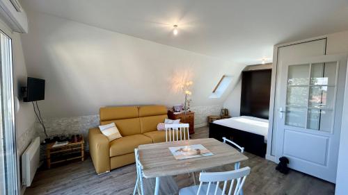 un salon avec un canapé et une table dans l'établissement Le calypso de la Baie, au Crotoy