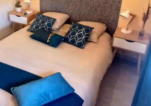 un lit avec quatre oreillers dessus dans l'établissement Charmante maison lumineuse avec piscine, jolie vue, à Potelières