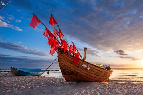 a wooden boat sitting on the beach at Kimpi 3 in Ostseebad Koserow