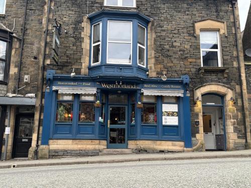 a building with a blue storefront on a street at The Westmorland Inn in Bowness-on-Windermere