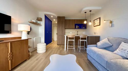 un salon avec un canapé et une cuisine dans l'établissement La Maison Bleu, au Crotoy