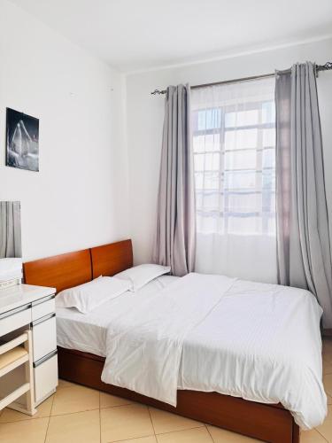 a bedroom with a bed and a window at Cozy Homes in Nairobi