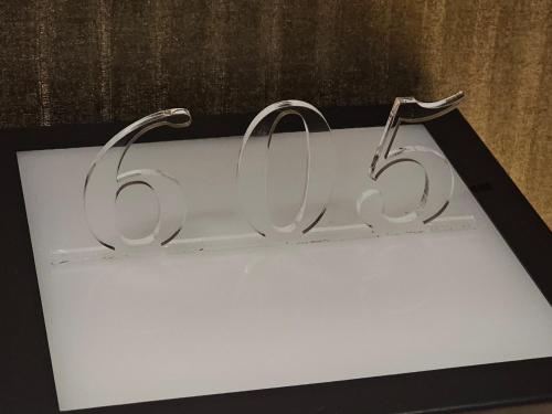 a metal sign with the number sixtyfive on it at HOTEL The KAISER -全室人工ラドン温泉- in Kanie