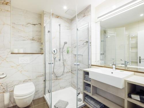 a bathroom with a shower and a toilet and a sink at Hapimag Ferienwohnungen Berlin Zoo in Berlin