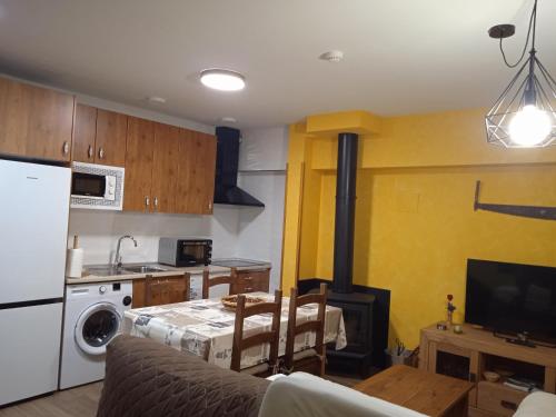 a kitchen with a table and a kitchen with a stove at Granja Las Callejuelas in Casla