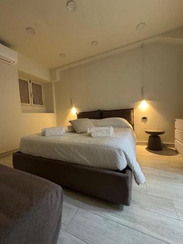 a bedroom with a large bed with white sheets at Tecla Apartment in Reggio di Calabria