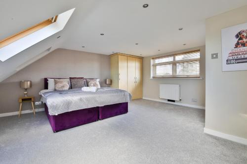 a bedroom with a purple bed and a staircase at Spacious & Modern Triple-Story Cardiff Home with Pool Table in Cardiff