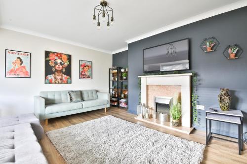 a living room with a couch and a fireplace at Spacious & Modern Triple-Story Cardiff Home with Pool Table in Cardiff