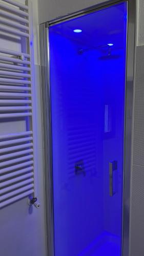 una doccia con illuminazione blu in bagno di Poderi S Luca ad Alba