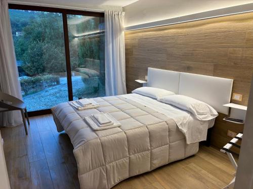una camera da letto con un letto grande e una grande finestra di Poderi S Luca ad Alba