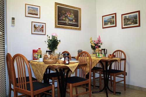 ein Esszimmer mit Tischen und Stühlen mit Blumen in der Unterkunft Emanuela B&B in Rom