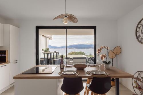 - une cuisine avec une table à manger et une vue sur l'océan dans l'établissement Le Calypso B01 - Climatisé avec vue mer, à Grosseto-Prugna
