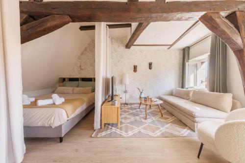 ein Schlafzimmer mit einem Bett und einer Couch in der Unterkunft L’Alcôve Bourbonnaise - Au coeur de Montluçon in Montluçon