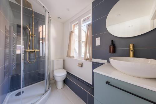 ein Badezimmer mit Waschbecken, Toilette und Spiegel in der Unterkunft L’Alcôve Bourbonnaise - Au coeur de Montluçon in Montluçon