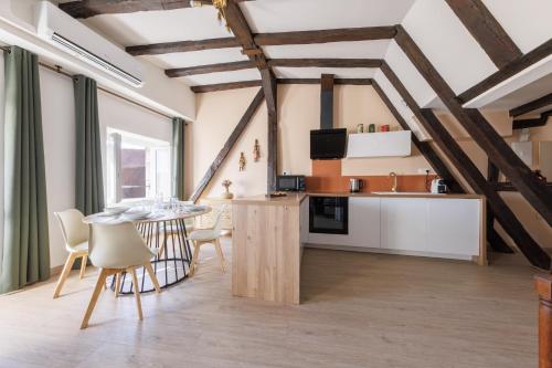une cuisine et une salle à manger avec une table et des chaises dans l'établissement L’Alcôve Bourbonnaise - Au coeur de Montluçon, à Montluçon