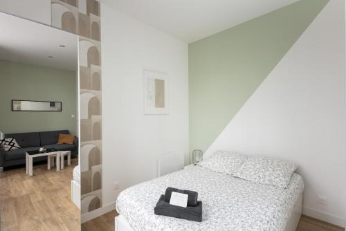 une chambre blanche avec un lit et un miroir dans l'établissement Le Terrible, à Brest