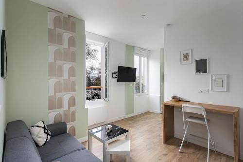 un salon avec un canapé et un bureau dans l'établissement Le Terrible, à Brest