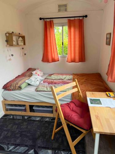 a small bedroom with a bed and a desk at Bauernhof Glamping mit Alpakas und Ziegen in Thalmässing