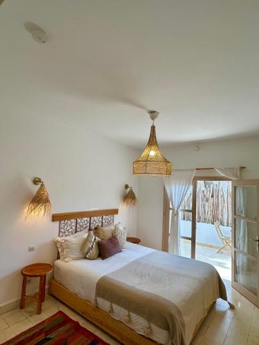 a bedroom with a large bed and a pendant light at Villa Nour in Essaouira