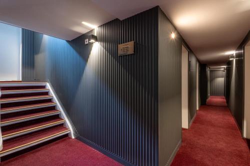 a hallway with stairs and a blue wall at Hotel Johannisberg Bad Homburg in Bad Homburg vor der Höhe