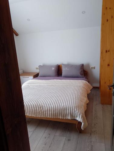 a bedroom with a bed with a striped bedspread at Ехо Тростяну in Slavske