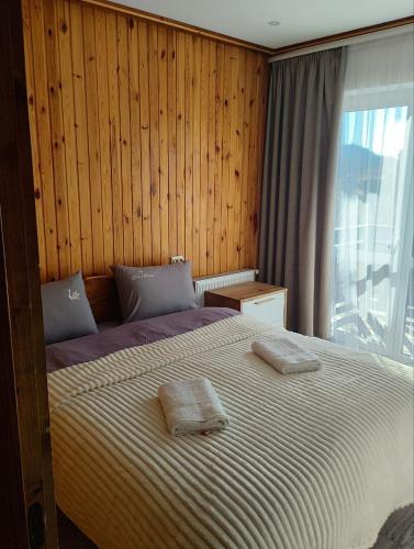 a bedroom with a bed with two towels on it at Ехо Тростяну in Slavske
