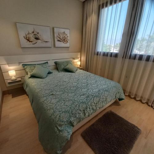 サラーラにあるGarden Villa - Hawana Salalahのベッドと大きな窓のある寝室