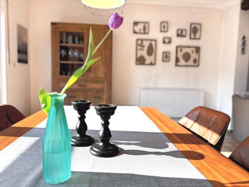 a table with two black candlesticks and a blue vase at Ferienhaus Wacholderhain in Haselünne