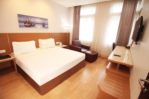 a hotel room with a bed and a television at Hotel Astoria Lampung in Lampung