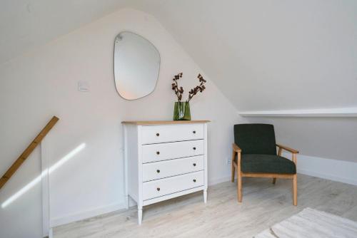 a room with a dresser and a mirror and a chair at Maison trois chambres avec cour, parking gratuit in Croix