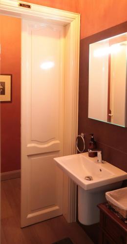 a bathroom with a white sink and a mirror at Villa Lucini 1886 Garden Apt near Lake Como and Milan in Rovagnate