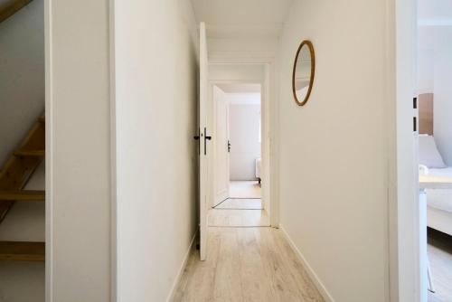a hallway with white walls and a mirror at Maison trois chambres avec cour, parking gratuit in Croix