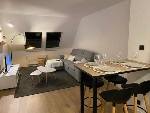 - un salon avec un canapé et une table avec des verres à vin dans l'établissement Appartement - Cambrai, à Cambrai