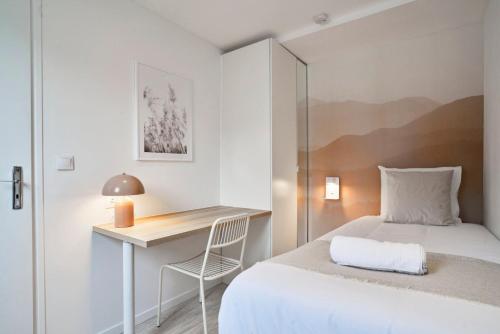 a small bedroom with a bed and a desk at Maison trois chambres avec cour, parking gratuit in Croix