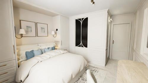 a white bedroom with a large white bed in it at Hôtel Maison Turenne in Martel