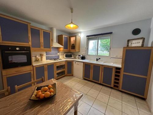 une cuisine avec une table avec un bol de fruits dessus dans l'établissement L'allee des charmes, à Aire-sur-lʼAdour