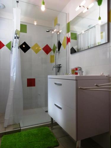 une salle de bain avec un lavabo et une douche avec un miroir dans l'établissement La dugue ouest, à Montsoué