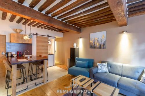 un salon avec un canapé bleu et une table dans l'établissement La Cachette de Lucie Heart of Honfleur 100m from the Port 2 Guests, à Honfleur