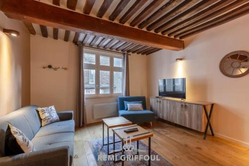 un salon avec un canapé et une télévision dans l'établissement La Cachette de Lucie Heart of Honfleur 100m from the Port 2 Guests, à Honfleur