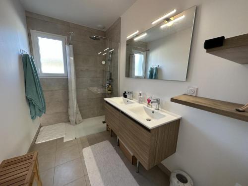 un baño con lavabo y ducha en La villa caroline, en Léon