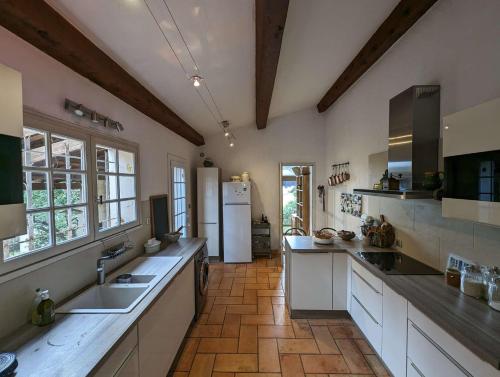 Il comprend une grande cuisine avec des placards blancs et un réfrigérateur. dans l'établissement Maison provençale 4 chambres entre Six Fours les plages et les Sablettes, à La Seyne-sur-Mer
