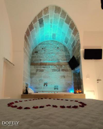 a room with a blue stone wall and a bed at Dofely - Suite by the Sea in Polignano a Mare