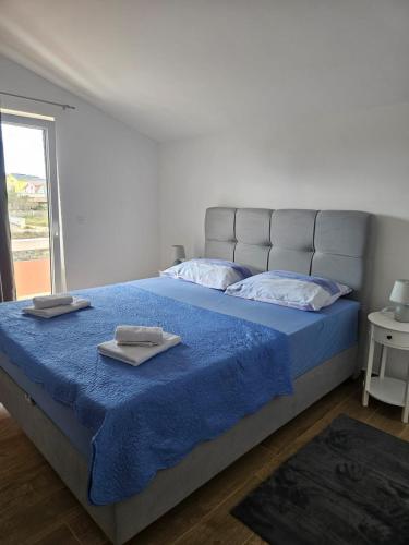 a bedroom with a bed with two towels on it at Apartman Tamaris in Vir