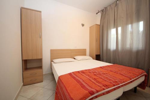 a small bedroom with a bed and a dresser at Villa Debby appartamento 01 in Rosolina Mare