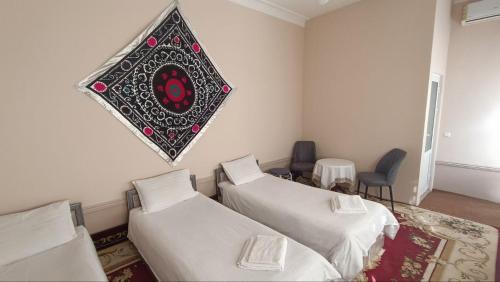 Una habitación con dos camas y un cuadro en la pared. en Sogda, en Samarkand